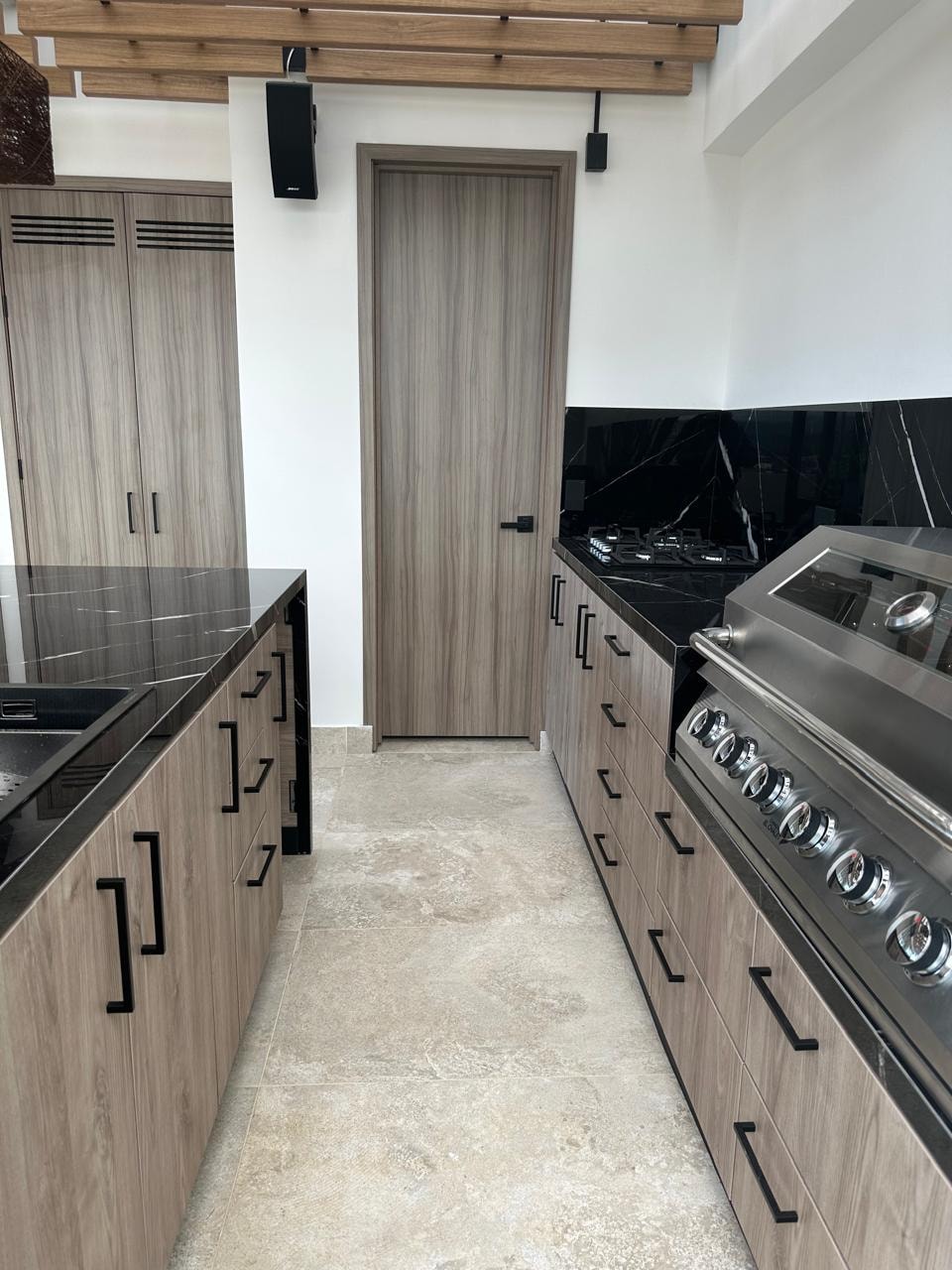 Detalle de cocina con gabinetes en madera y mármol negro